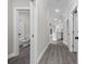 Hallway with gray wood-look flooring, white doors, and leading to the kitchen and living area at 627 Bonaventure Dr. # 203, Myrtle Beach, SC 29577