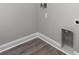 Empty laundry room hookups feature gray wood flooring and white trim at 627 Bonaventure Dr. # 203, Myrtle Beach, SC 29577