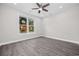 Bright bedroom featuring a modern ceiling fan, hardwood flooring, and a window with vibrant autumn foliage at 627 Bonaventure Dr. # 204, Myrtle Beach, SC 29577