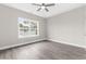 Bright bedroom with wood-look floors, ceiling fan, large window with views of surrounding greenery at 904 62Nd Ave. N # E, Myrtle Beach, SC 29572