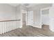 Hallway with neutral walls and wood-look flooring, leading to various rooms and a full bathroom at 904 62Nd Ave. N # E, Myrtle Beach, SC 29572