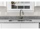Close-up of kitchen sink and faucet with granite countertops, white cabinets and window at 904 62Nd Ave. N # E, Myrtle Beach, SC 29572