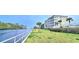 Condo with waterfront view featuring a well-maintained lawn, white fence, and palm trees at 1100 Commons Blvd. # 606, Myrtle Beach, SC 29572
