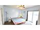 Bright bedroom with light blue walls, ceiling fan, and sliding glass door to a balcony at 1100 Commons Blvd. # 606, Myrtle Beach, SC 29572