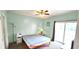 Bright bedroom with light green walls, ceiling fan, and sliding glass door to a balcony at 1100 Commons Blvd. # 606, Myrtle Beach, SC 29572