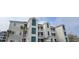 Exterior of a three story condo featuring a light colored facade with teal shutters and palm trees at 1100 Commons Blvd. # 606, Myrtle Beach, SC 29572