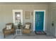 Charming front porch with stylish decor, seating, and a vibrant blue door, creating a welcoming entry at 1221 Tidewater Dr. # 1922, North Myrtle Beach, SC 29582