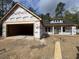 New home under construction with lumber and weather-resistant house wrap on the exterior and attached garage at 1274 Pinetucky Dr., Galivants Ferry, SC 29544
