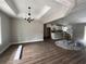 Bright open-concept living room with wood floors, tray ceilings, modern lighting, and kitchen view at 1274 Pinetucky Dr., Galivants Ferry, SC 29544