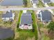 Aerial view of home featuring lawn, mature landscaping, patio with umbrellas, and a pond at 129 Astoria Park Loop, Conway, SC 29526