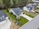 Aerial view of a grey home featuring manicured lawn, palm trees and mature foliage at 129 Astoria Park Loop, Conway, SC 29526