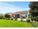 A well-manicured backyard showcasing a patio with an outdoor dining area and manicured shrubbery at 129 Astoria Park Loop, Conway, SC 29526