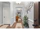 Inviting hallway with wood floors, neutral walls, decorative tree art, and elegant trim detail at 129 Astoria Park Loop, Conway, SC 29526
