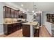 Open kitchen with granite countertops, stainless appliances, dark wood cabinetry and seating at 129 Astoria Park Loop, Conway, SC 29526