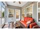 Inviting screened porch with an orange love seat and multiple windows, ideal for relaxation at 129 Astoria Park Loop, Conway, SC 29526