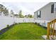 Lush backyard featuring a well-maintained lawn, garden, and white picket fence, perfect for outdoor relaxation at 1525 Capella Ln., Myrtle Beach, SC 29575
