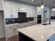 Modern kitchen boasts a large island, quartz counters, stainless steel appliances, and white cabinets at 242 River Edge Dr., Myrtle Beach, SC 29588