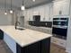 Modern kitchen boasts a large island, quartz counters, stainless steel appliances, and white cabinets at 242 River Edge Dr., Myrtle Beach, SC 29588