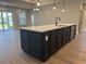 Modern kitchen island with stainless steel dishwasher and sink, quartz countertop, and black cabinets at 242 River Edge Dr., Myrtle Beach, SC 29588