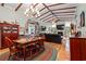 Inviting living and dining room features a wooden table, chandelier, fireplace, and exposed beam vaulted ceilings at 67 Kingsbury Pl., Georgetown, SC 29440