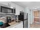Compact kitchenette with stainless steel appliances, mosaic backsplash, and granite countertops at 9550 Shore Dr. # 1026, Myrtle Beach, SC 29572