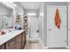 Elegant bathroom with double sinks, dark wood cabinets, tiled floors, and a glass-enclosed shower, creating a serene atmosphere at 1000 Oak Marsh Ln., North Myrtle Beach, SC 29582