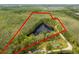 An aerial view showcasing the property and pond, surrounded by a lush treed boundary at 1030 Waccamaw Lake Dr., Conway, SC 29526