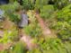 Aerial view of a secluded home with a dark roof, nestled within a dense forest near a flowing waterway at 1030 Waccamaw Lake Dr., Conway, SC 29526