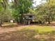Exterior view of elevated home with wooden stairs and porch, surrounded by trees and grass at 1030 Waccamaw Lake Dr., Conway, SC 29526