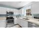 Bright kitchen featuring white cabinets, stainless steel appliances, and a window over the sink at 1068 Harbor Dr., Calabash, NC 28467