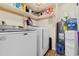 Functional laundry area featuring a washer, dryer, shelving and water heater, efficiently organized for convenience at 1068 Harbor Dr., Calabash, NC 28467
