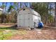 Exterior view of a shed with a metal roof, double doors, ladders and yard tools, providing outdoor storage at 1068 Harbor Dr., Calabash, NC 28467