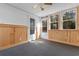 Bright sunroom with wood paneling, ceiling fan, large windows, and white trim offers versatile living space at 1068 Harbor Dr., Calabash, NC 28467