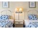 Cozy bedroom featuring two twin beds with blue floral bedding and stylish bedside lamps at 1207 S Ocean Blvd. # 51006, Myrtle Beach, SC 29577