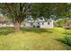 Expansive backyard showcasing a large tree, well-maintained lawn, and a quaint white home at 1287 Stalvey Ave., Myrtle Beach, SC 29577