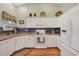 Kitchen features white appliances, wood floors, blue tiled backsplash, and bright lighting at 1292 Merion Ct., Murrells Inlet, SC 29576