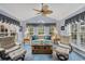 Bright sunroom with many windows, comfortable seating and a ceiling fan at 1292 Merion Ct., Murrells Inlet, SC 29576