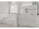 Modern bathroom featuring a tub and walk-in shower with glass enclosure and marble tiling at 1312 Ashboro Ct., Myrtle Beach, SC 29579