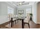 Dining area with modern chandelier, glass table, and ample natural light from multiple windows at 1312 Ashboro Ct., Myrtle Beach, SC 29579