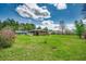 Expansive backyard featuring lush green grass and mature trees, a charming fence, and space at 144 Pink Dogwood Dr., Loris, SC 29569