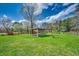 Backyard featuring a rustic shelter surrounded by a lawn, flowering trees, and shrubs at 144 Pink Dogwood Dr., Loris, SC 29569