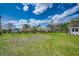Spacious backyard with a mix of grass, trees, flowering shrubs, and outbuildings at 144 Pink Dogwood Dr., Loris, SC 29569