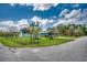 Street corner with well-maintained yard and lush landscaping, next to a paved road at 144 Pink Dogwood Dr., Loris, SC 29569
