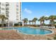 Inviting outdoor pool with lounge chairs and lush palm trees at oceanfront condo complex at 1605 S Ocean Blvd. # 1114, Myrtle Beach, SC 29577