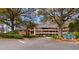 Three-story exterior shows lush landscaping, designated parking, and a sign for Arrowhead Court at 180 Rothbury Circle # 203, Myrtle Beach, SC 29572