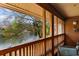 Covered patio with a wood railing offers a peaceful view of the lake and lush greenery at 180 Rothbury Circle # 203, Myrtle Beach, SC 29572