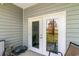 Enclosed balcony with double glass doors, gray siding and outdoor furnishings at 189 Ella Kinley Circle # 203, Myrtle Beach, SC 29588