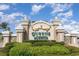 Queens Harbour entrance sign with stucco columns, a decorative crown, and lush landscaping at 189 Ella Kinley Circle # 203, Myrtle Beach, SC 29588