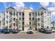 Three-story condo building with outdoor staircases, parking and light green siding at 189 Ella Kinley Circle # 203, Myrtle Beach, SC 29588
