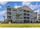 Stylish condo building featuring multiple screened balconies, verdant landscaping, and manicured lawn at 189 Ella Kinley Circle # 203, Myrtle Beach, SC 29588